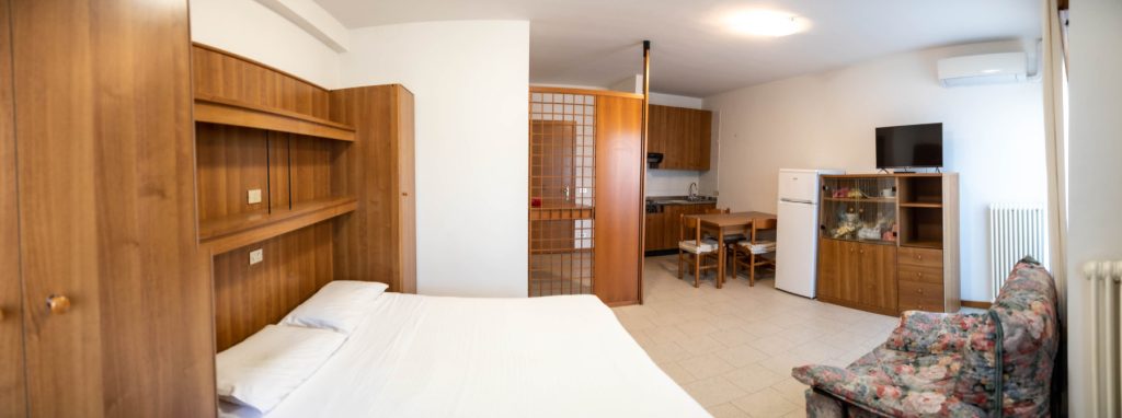 Monolocale, area soggiorno e riposo arredato